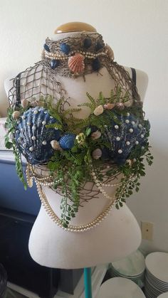 a mannequin is adorned with beads, pearls and other things like flowers on it