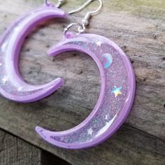 Pastel Goth Lavender and Pink Crescent Moon and Stars Holographic Glitter 3D printed resin earrings Lightweight Free Shipping MTcoffinz Placement of stars and mini moons will vary, making your pair one of a kind. Colors will be as shown. Message me if you want to create a pair with custom colors. 3D printed here in my studio, these are surprisingly lightweight even though they are quite large. These are made with pla and resin printers, filled with glitter and laser cut shapes Each earring measu Purple Glitter Jewelry Gift, Purple Glitter Jewelry For Gifts, Purple Glitter Earrings For Gift, Purple Resin Jewelry For Party, Purple Resin Party Jewelry, Cute Purple Resin Jewelry, Purple Plastic Jewelry As Gift, Purple Plastic Jewelry Gift, Equinox Aesthetic