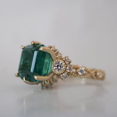 Bring elegance and sophistication to your jewelry collection with this one of a kind Emerald Knightsbridge Diamond Ring. Handcrafted in your choice of 14K and 18K Gold, this regal piece features a stunning natural emerald centerpiece surrounded by dazzling diamonds. As impressive as it is dreamy, this ring is sure to become a treasured family heirloom. Only one available. 14K or 18K solid gold Natural asscher cut emerald. 4.44 carat weight. Comes with a certificate. Natural round white diamonds. Elegant 14k Stamped Emerald Ring, Luxury 14k Gold Emerald Ring For Formal Occasions, Luxury 14k Gold Diamond Ring With Accent Stones, Exquisite Yellow Gold Emerald Diamond Ring, Luxury 14k Gold Emerald Ring With Halo Setting, Luxury 14k Gold Emerald Wedding Ring, Luxury Gold Emerald Ring With Halo Setting, Luxury Yellow Gold Cluster Ring With Emerald Cut, Exquisite Yellow Gold Emerald Ring