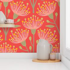 an orange wallpaper with pink flowers and green leaves on it, next to a white vase