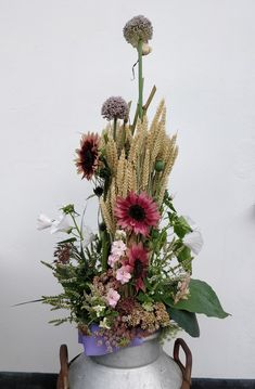 a large metal pot with flowers in it