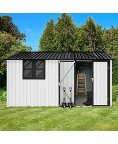 a small white shed sitting in the grass