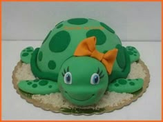 a green turtle cake with a bow on it's head