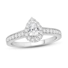 a white gold engagement ring with an oval cut diamond in the center and pave set shoulders