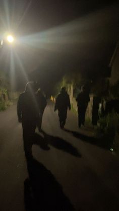 some people are walking down the street at night