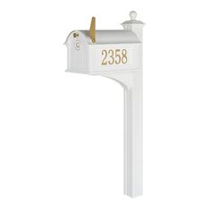 a white mailbox with gold numbers on the front and back of it's post