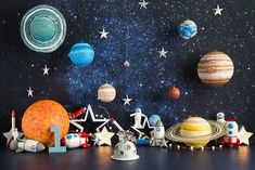 an assortment of solar system toys on a black surface with stars and planets in the background