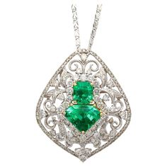 Art Nouveau carved 18k white gold pendant, with two emerald center stones; one shield, and one emerald cut, secured by 18k yellow gold prong setting. With 141 round-cut diamond side stones, this multi-stone pendant necklace is truly a harmonious blend of timeless elegance with vintage allure. The carved filigree white gold setting plays perfectly with the stacked emerald center stones. A true one-of-one fine jewelry piece for the seasoned collector. The emeralds are both eye clean, with a richly dark green hue. Item Details: - Type: Pendant Necklace - Metal: 18K White, Yellow Gold - Weight: 12.03 Grams - Style: Art Nouveau - Chain Length: 16 Inched - Pendant Size: 3.9 x 3.25 CM ______________________________________ Emerald Details(1): - Type: Emerald - Carat: 3.90 - Cut: Sheild - Color: G