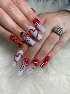 a woman's hands with red and white nail designs