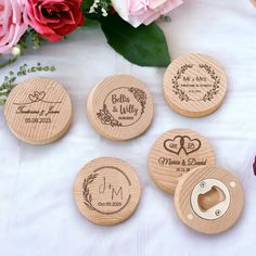 four personalized wooden coasters on a table with pink roses and flowers in the background