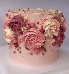 a pink cake decorated with flowers and pearls