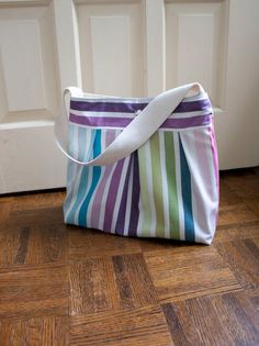 a multicolored striped bag sitting on the floor in front of a white door