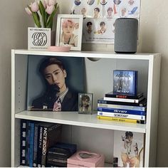 a book shelf with books and pictures on it