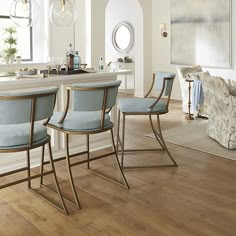 a kitchen with wooden floors and blue chairs