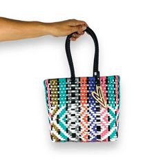 Indulge in luxury with our Bliss Totes, featuring the timeless Maria Victoria Bag in a captivating handwoven design. Made from repurposed plastic, this versatile bag is perfect for poolside lounging, beach outings, grocery excursions, and everyday tasks. With easy cleaning and fade-resistant colors, you'll never want to leave without it. Details: • Made in Mexico • Weight: 1 lb (453.59 g) • Dimensions: 8 x 4 x 8 in (20.3 x 10.2 x 20.3 cm) About this product: Color: Multicolor design Size: Mini Tote Perfect for everyday, indoor and outdoor activities. Multicolor Recyclable Beach Bag For Vacation, Beach Tote Bag In Plastic, Casual Beach Bags Made Of Plastic, Blue Plastic Beach Bag, Blue Plastic Beach Bags, Multicolor Plastic Travel Bag, Plastic Tote Beach Bag, Plastic Beach Tote Bag, Summer Travel Beach Bag Made Of Plastic