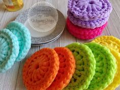 colorful crochet dishcloths and dishes on a table with a plate in the background