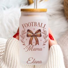 a woman holding up a white can with a brown bow on it's lid