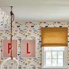 a child's room with wallpaper and pictures on the walls, including animals