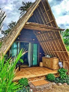 a small house made out of bamboo with a thatched roof and wooden flooring