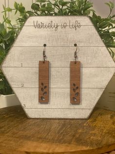 the earrings are made out of wood and have paw prints on them, along with words that read variety of life