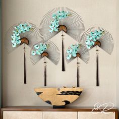 decorative wall art with blue flowers and palm trees on the top of a buffet table