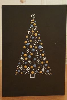 a black card with a christmas tree made out of small balls and dots on it