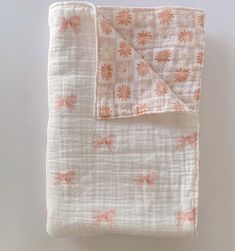 an orange and white blanket with pink flowers on it