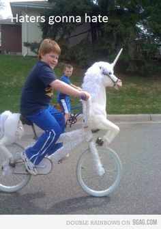 two young boys riding on the back of a white unicorn bike