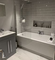 a bathroom with a sink, bathtub and shower stall in the middle of it