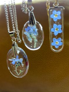 three glass pendants with blue flowers on them