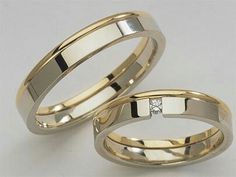 two gold wedding bands with diamonds on them