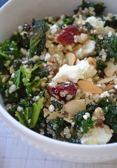 a white bowl filled with broccoli, cauliflower and nuts