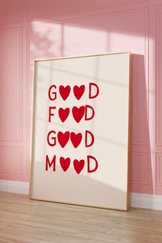 a white frame with red hearts on it in front of a pink wall and wooden floor