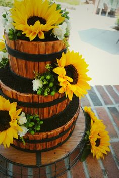 a three tiered cake with sunflowers on top