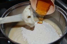 a mixing bowl filled with sugar and liquid being poured into the mixture to be mixed together