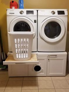 two washers and a dryer sitting on top of each other in a room