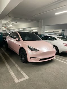 a pink tesla parked in a parking garage