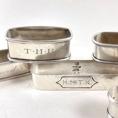 five silver metal containers sitting on top of a white table