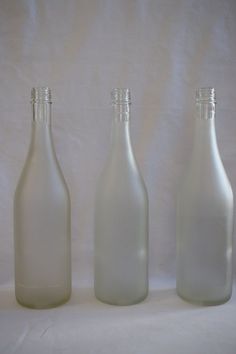 three empty glass bottles sitting next to each other