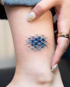 a woman's leg with a small tattoo on her left side, which has blue flowers