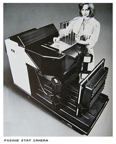 a woman standing next to a stack of black and white computer monitors on top of each other