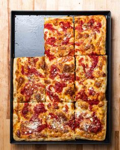 four square slices of pizza sitting on top of a black pan covered in cheese and pepperoni