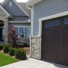 a house with two brown garage doors in front of it