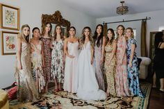 a group of women standing next to each other in front of a mirror and rug