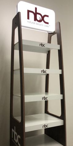 a tall wooden shelf with white shelves on it's sides and the logo for nbc