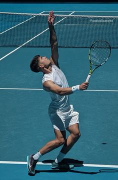 a man holding a tennis racquet on top of a tennis court