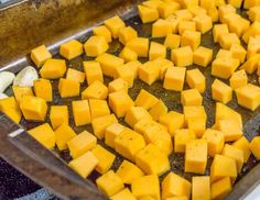 there are many cubes of cheese on the baking sheet in the oven and ready to be cooked