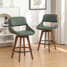 two green barstools sit in front of a white wall and wooden flooring