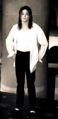 a black and white photo of a woman standing with her hands on her hips