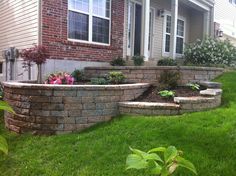 a brick retaining wall in front of a house